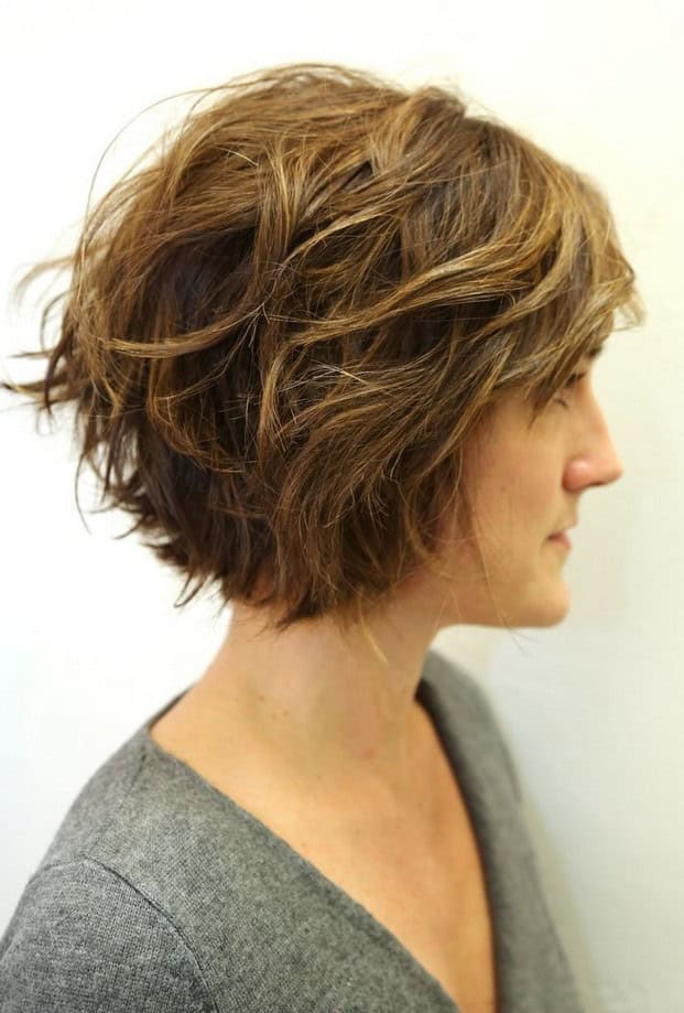 Short angled light brown wavy bob with bangs