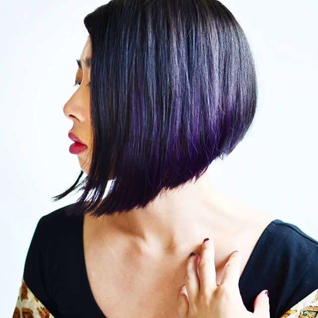 Slick angled bob for thick straight hair with dark purple highlights