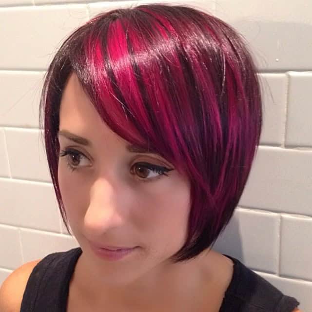 Straight bob with side-swept bangs and maroon chunks of color