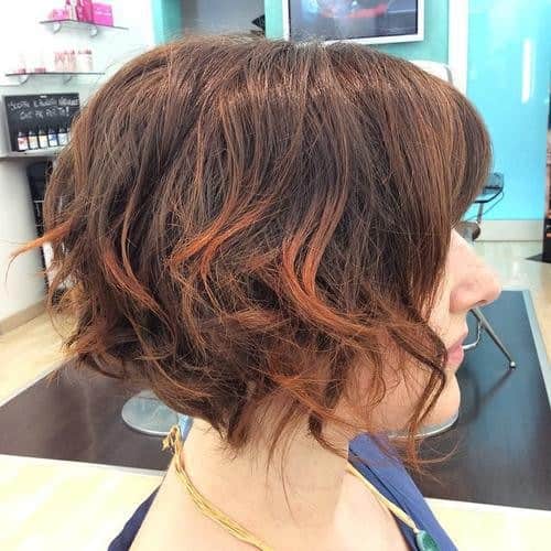 Wavy short bob with copper highlights and blunt bangs